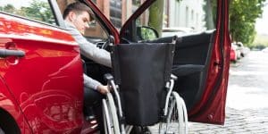 Lewis Reed Group | Wheelchair Accessible Vehicles | Man getting from car to wheelchair